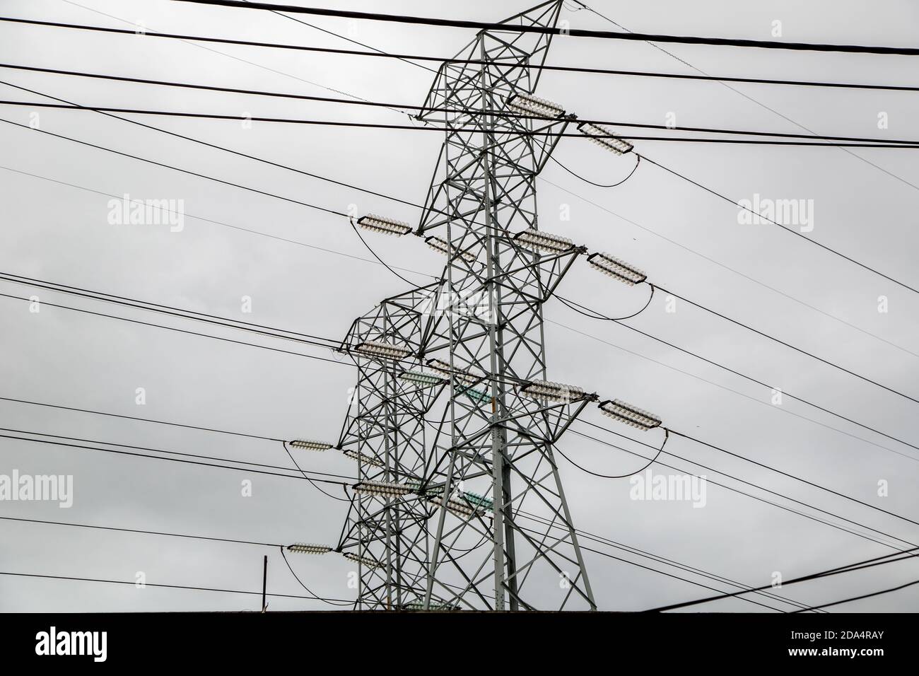 Low angle shot of transmission towers under a cloudy sky on a gloomy ...