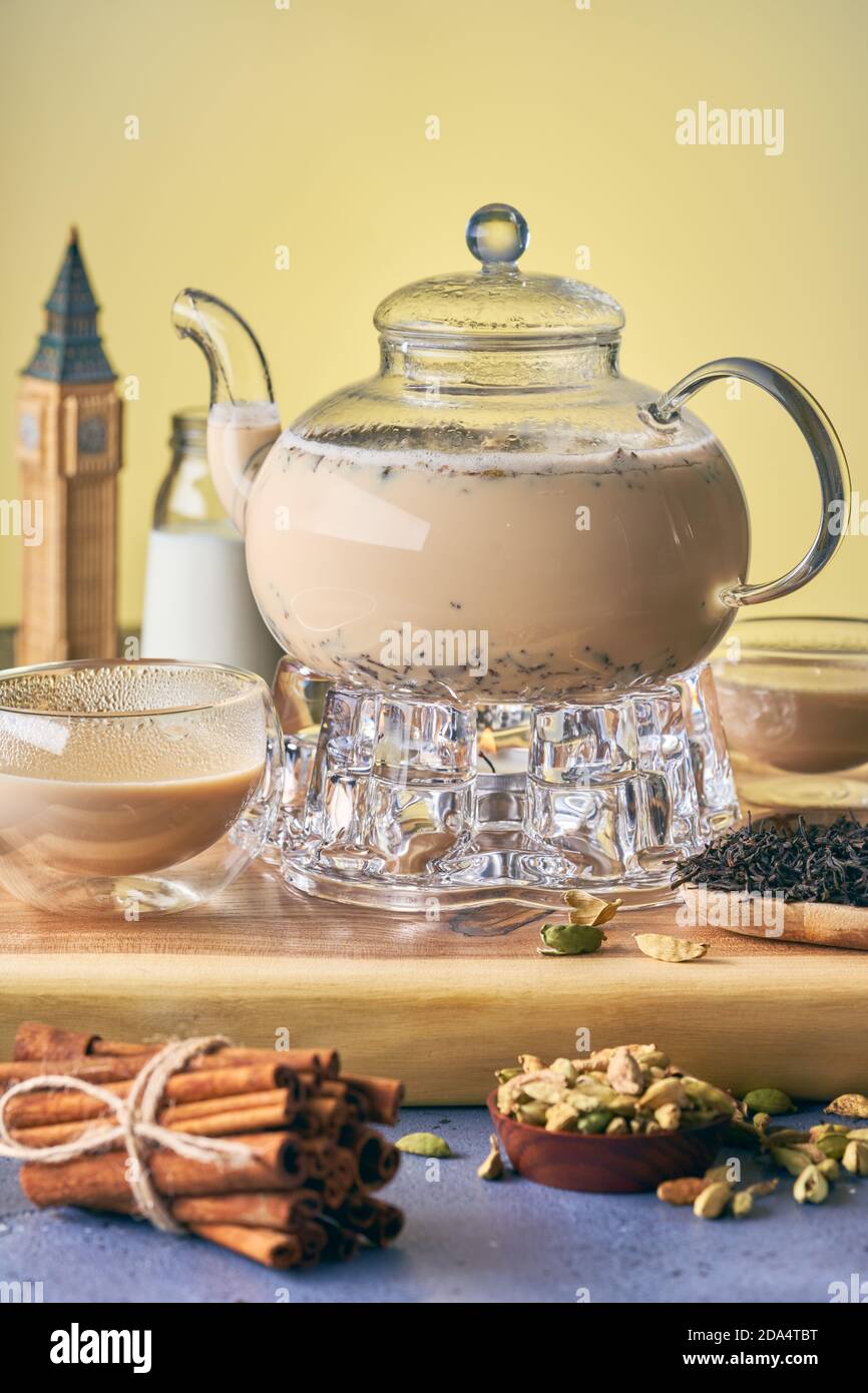 Masala tea in a teapot is heated by a candle. In the frame is the glass ...