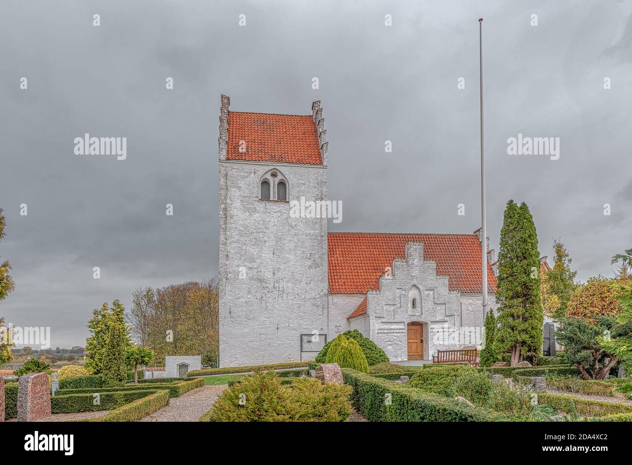 A medieval white stone-churh with a belltower in the danish countryside, Tuse, Denmark, November 5, 2020 Stock Photo