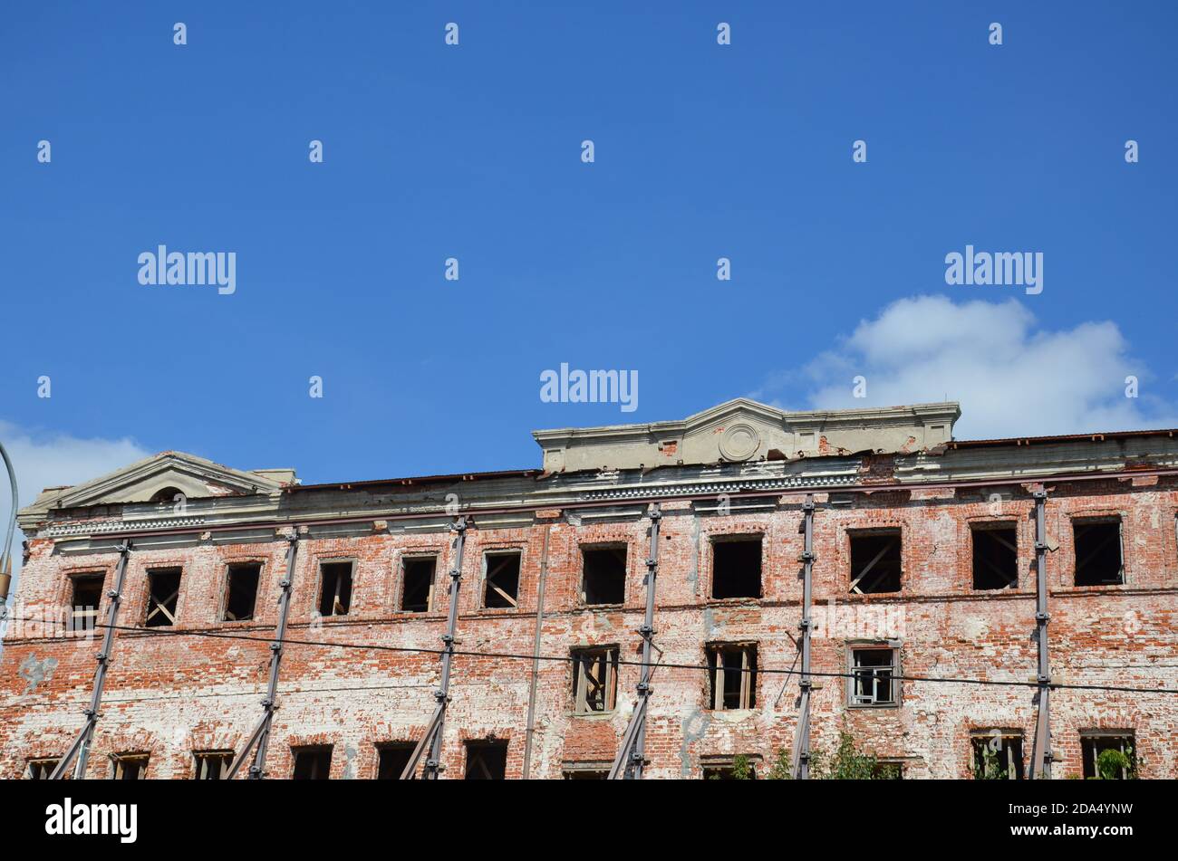 Brick facade of an abandoned old building with windows Stock Photo - Alamy