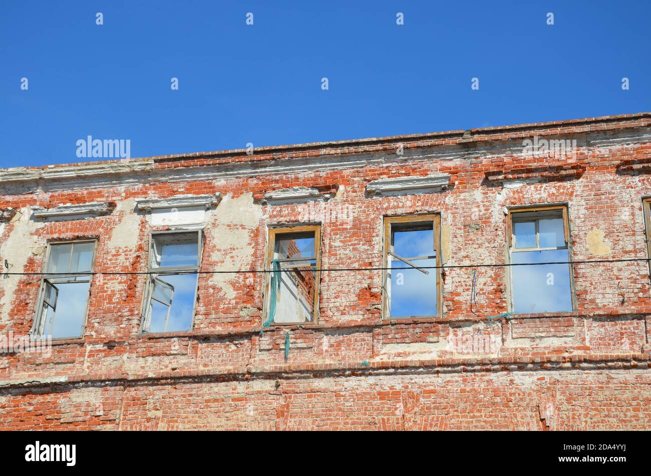 Brick facade of an abandoned old building with windows Stock Photo - Alamy