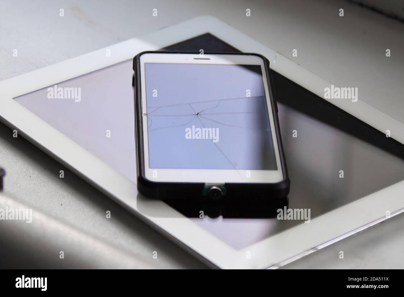 Colored highlights of a broken mobile phone screen in the reflection of  daylight Stock Photo - Alamy