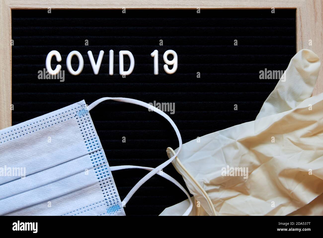 The inscription Covid 19 on a black background, medical masks and latex ...