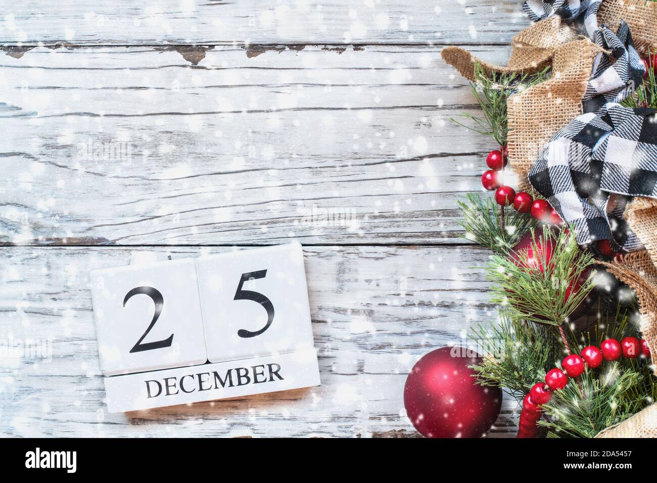 December 25 background. Wood calendar blocks with the date December 25th to mark Christmas Day with bokeh lights, black and white buffalo check and re Stock Photo