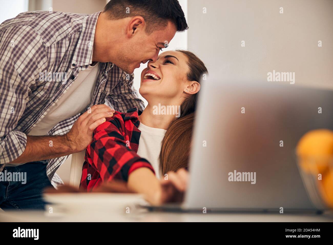 Romantic husband distracting his freelancer wife from work Stock Photo