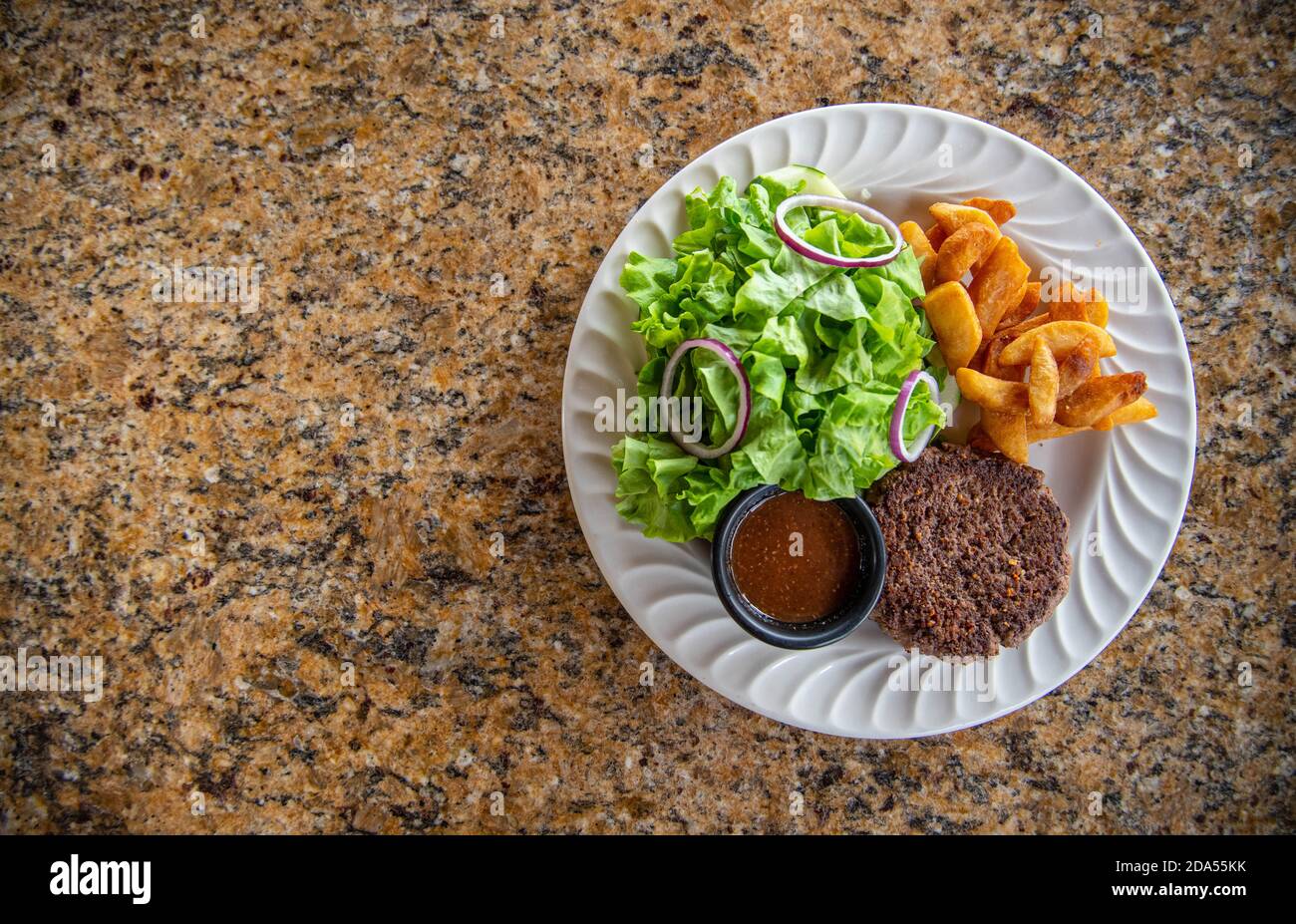 Hamburger patty with green salad and steak fries Stock Photo