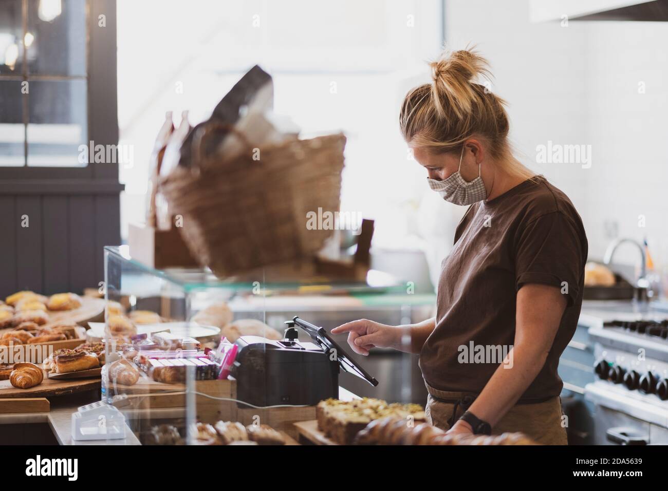 Blond waitress wearing face mask working in a cafe Stock Photo - Alamy