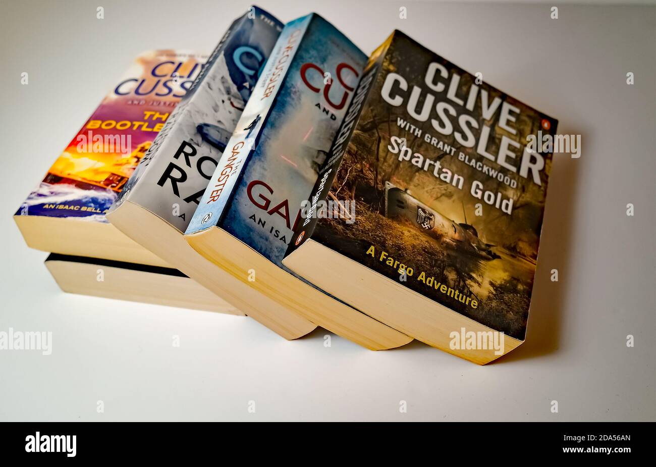 Norwich, Norfolk, UK – November 08 2020. Illustrative editorial photo of a selection of thriller genre paperback books written by Clive Cussler isolat Stock Photo