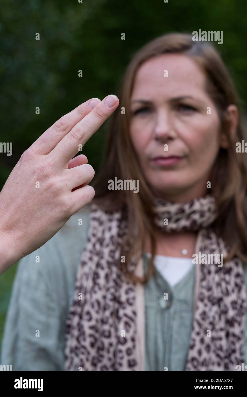 Woman focussing on the hands of a therapist with fingers extended Stock Photo
