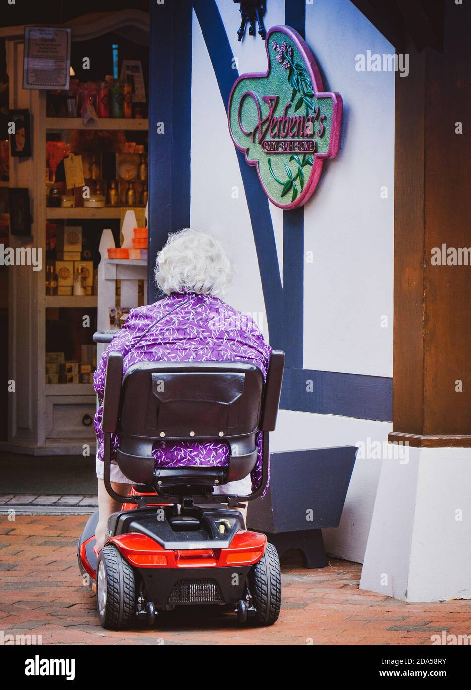 Rear View of Elderly woman in mobility scooter entering a Body & Bath
