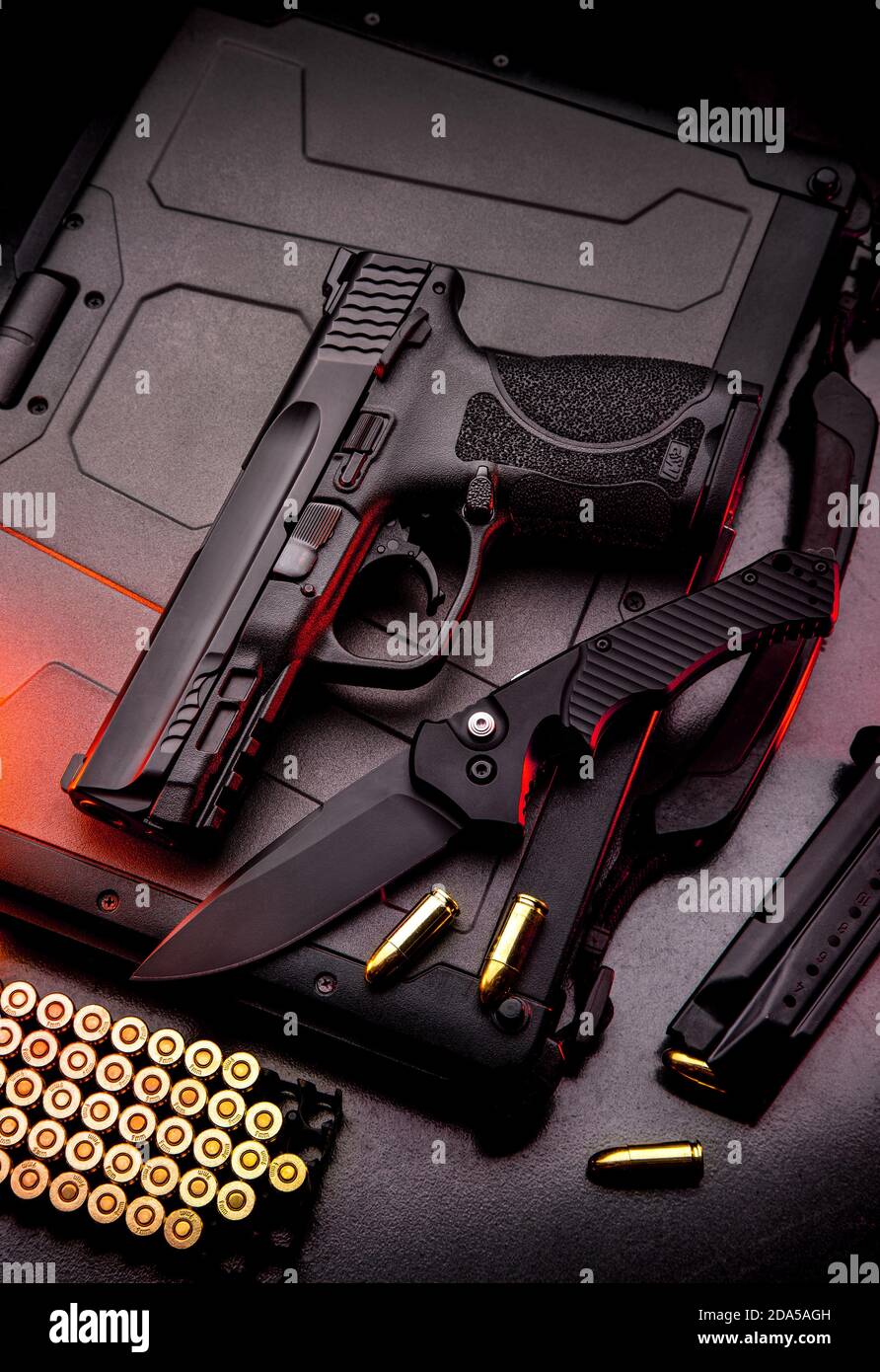 A pistol, cartridges for it and a folding knife on a dark background.  Self-defense and survival kit. Compact edged weapons and firearms Stock  Photo - Alamy
