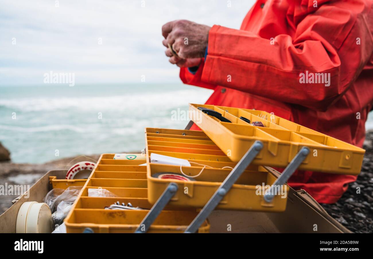 Fisherman with fishing equipment box. Stock Photo
