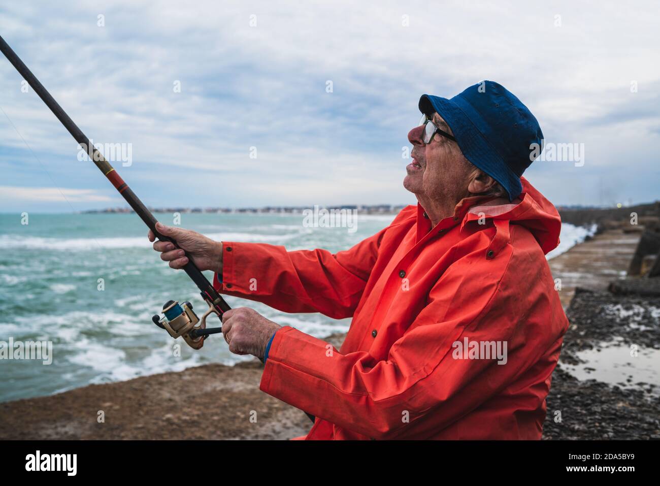 Senior man fishing in the sea. Stock Photo