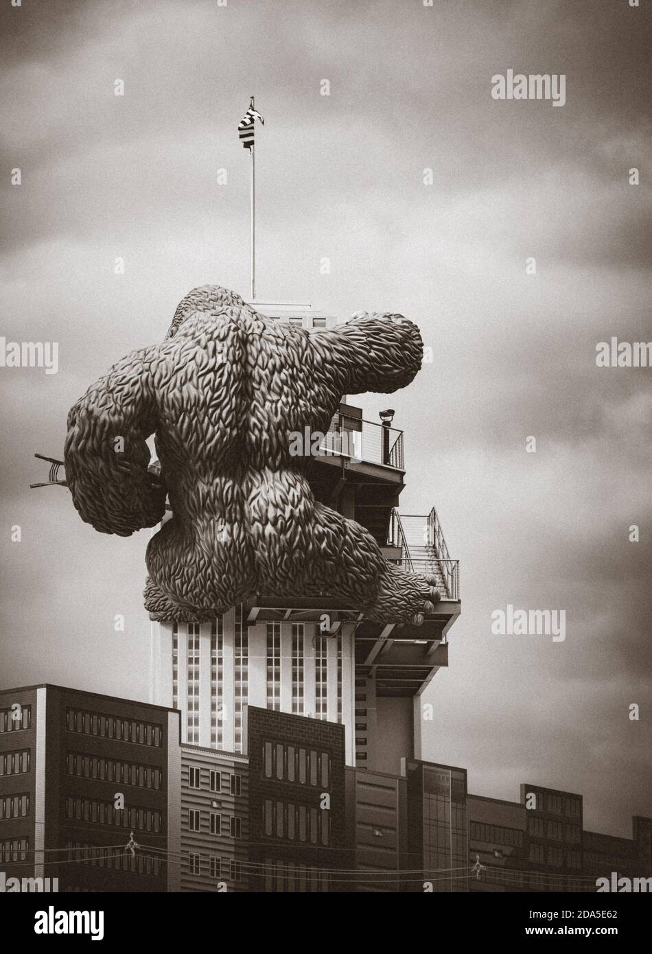 Surreal Rear view of replica of King Kong climbing a building while holding a bi-lane at tourist atttaction in Gatlinburg, TN in sepia tone Stock Photo