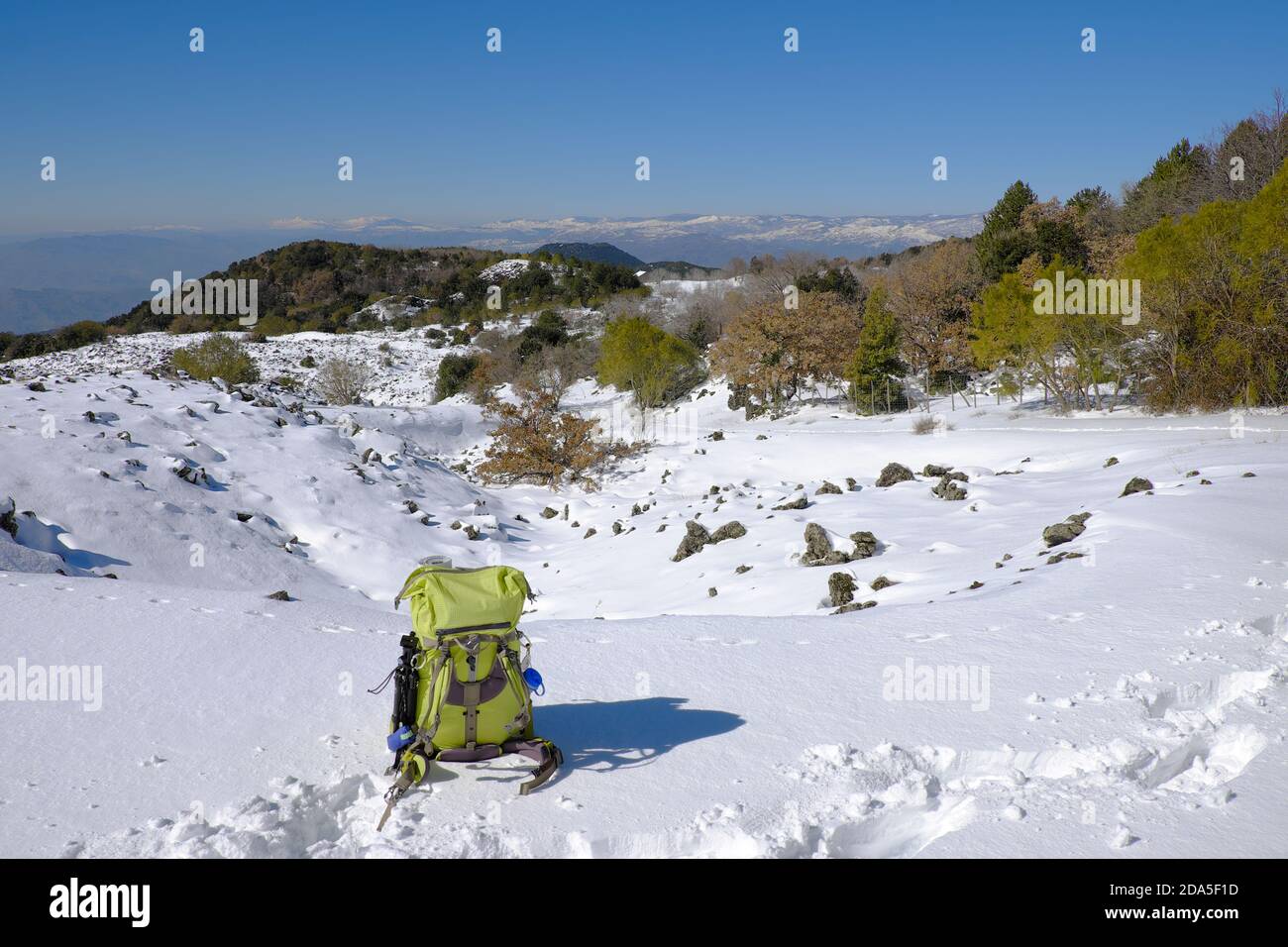 winter scene with green backpack in Etna Park, Sicily Stock Photo
