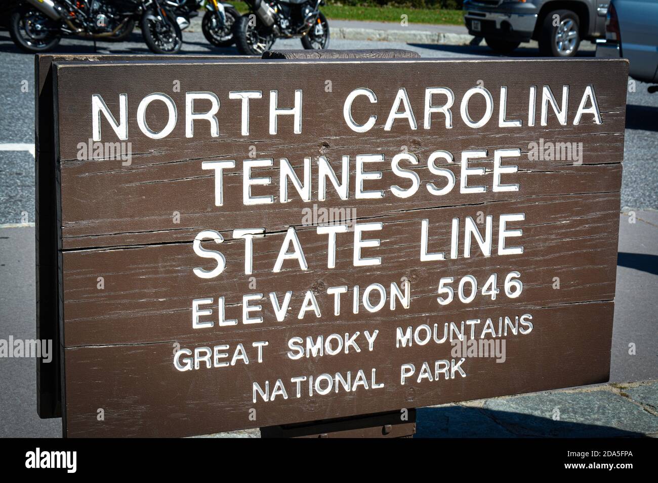 Close up of National Park rustic wooden roadside sign marking the North Carolina and Tennessee State line in the Great Smoky Mountains at an elevation Stock Photo