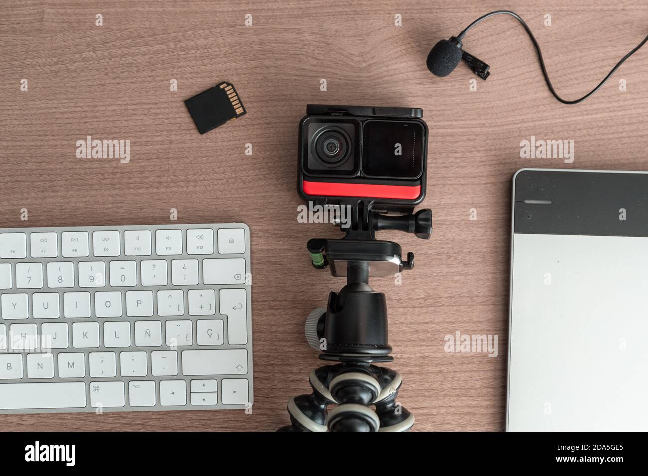 different technological gadgets on the work desk, there is a camera, microphone, sd card, keyboard, technology and modern objects Stock Photo