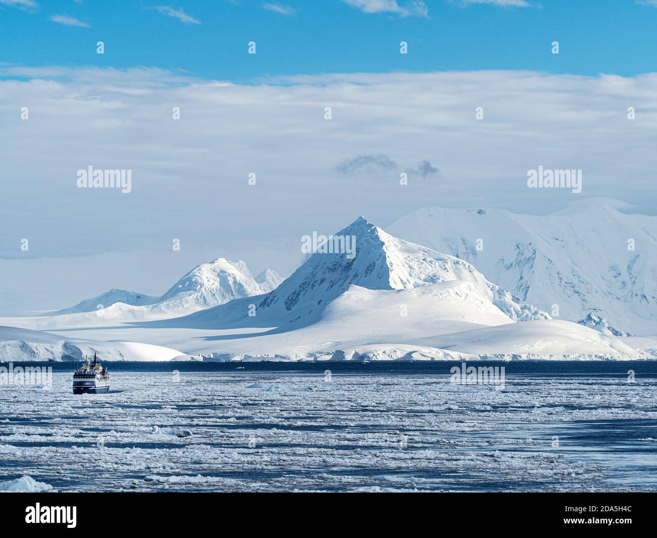 An expedition ship in heavy brash ice in the Yalour Islands, Antarctica. Stock Photo