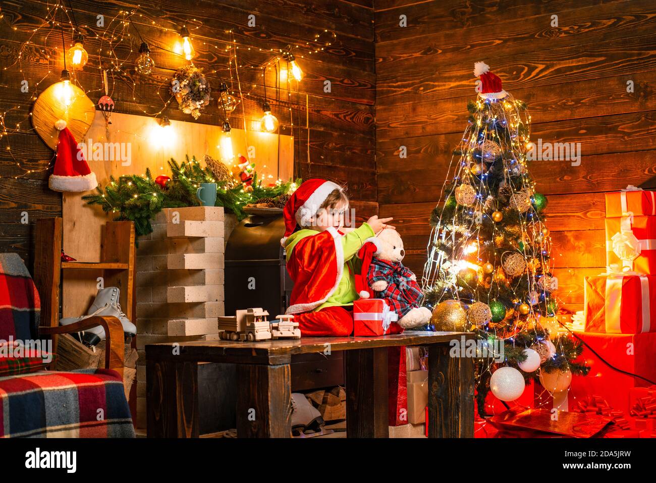 Little Santa Claus helper elf with a magic gift for Christmas. Joy and  happiness. Bright New Years interior. Indoor. Little boy with Christmas  Stock Photo - Alamy, image size:1300x957