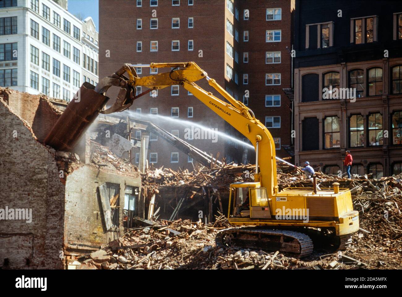 Workers and Claw Machine Tear Down a Building to Prepare for New