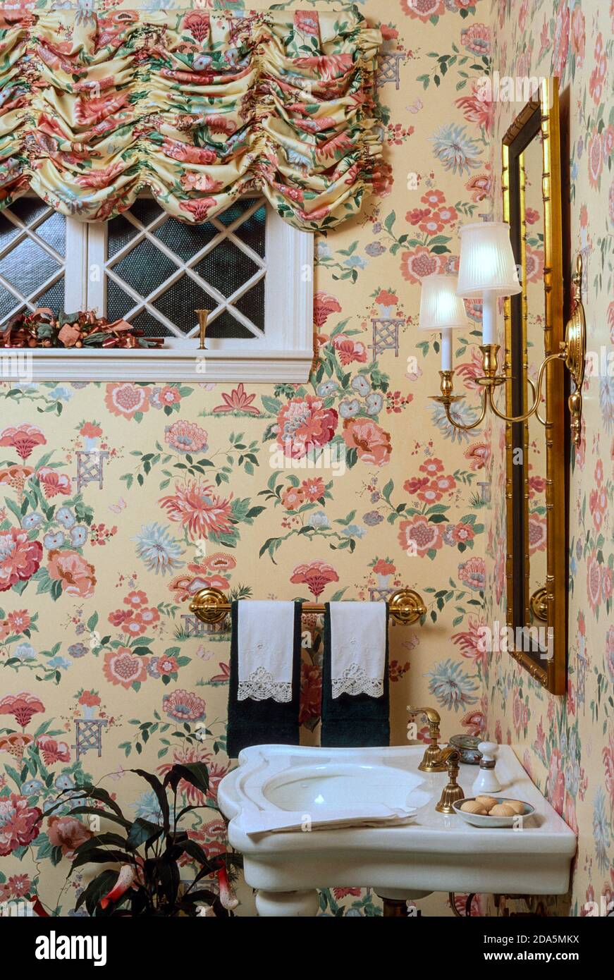 Designer vintage powder room features a pedestal sink and floral