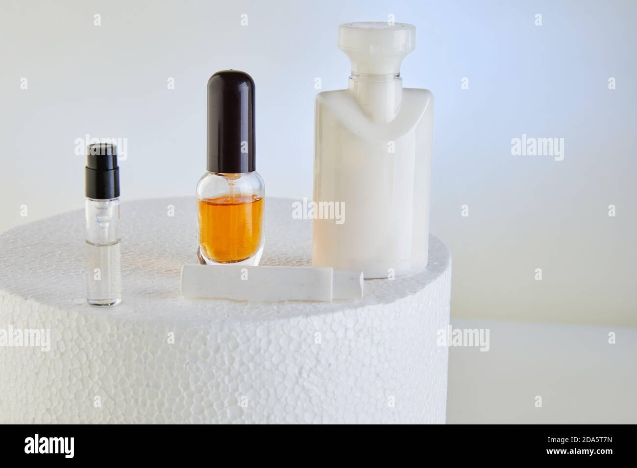 A variety of blanks for hand cream, perfumery, shower gel, bottles without labels on a white round podium on a cream background. Stock Photo
