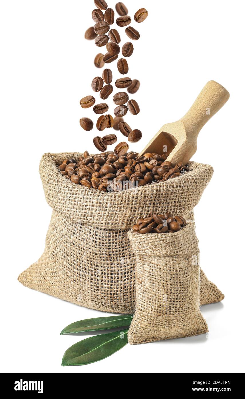 Bags with falling coffee beans on white background Stock Photo - Alamy