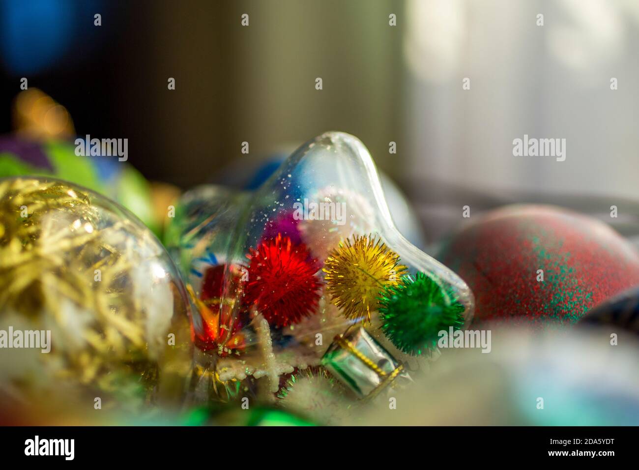 Glass Christmas ornaments made by children including clear star ornament  filled with sparkly pom poms Stock Photo - Alamy