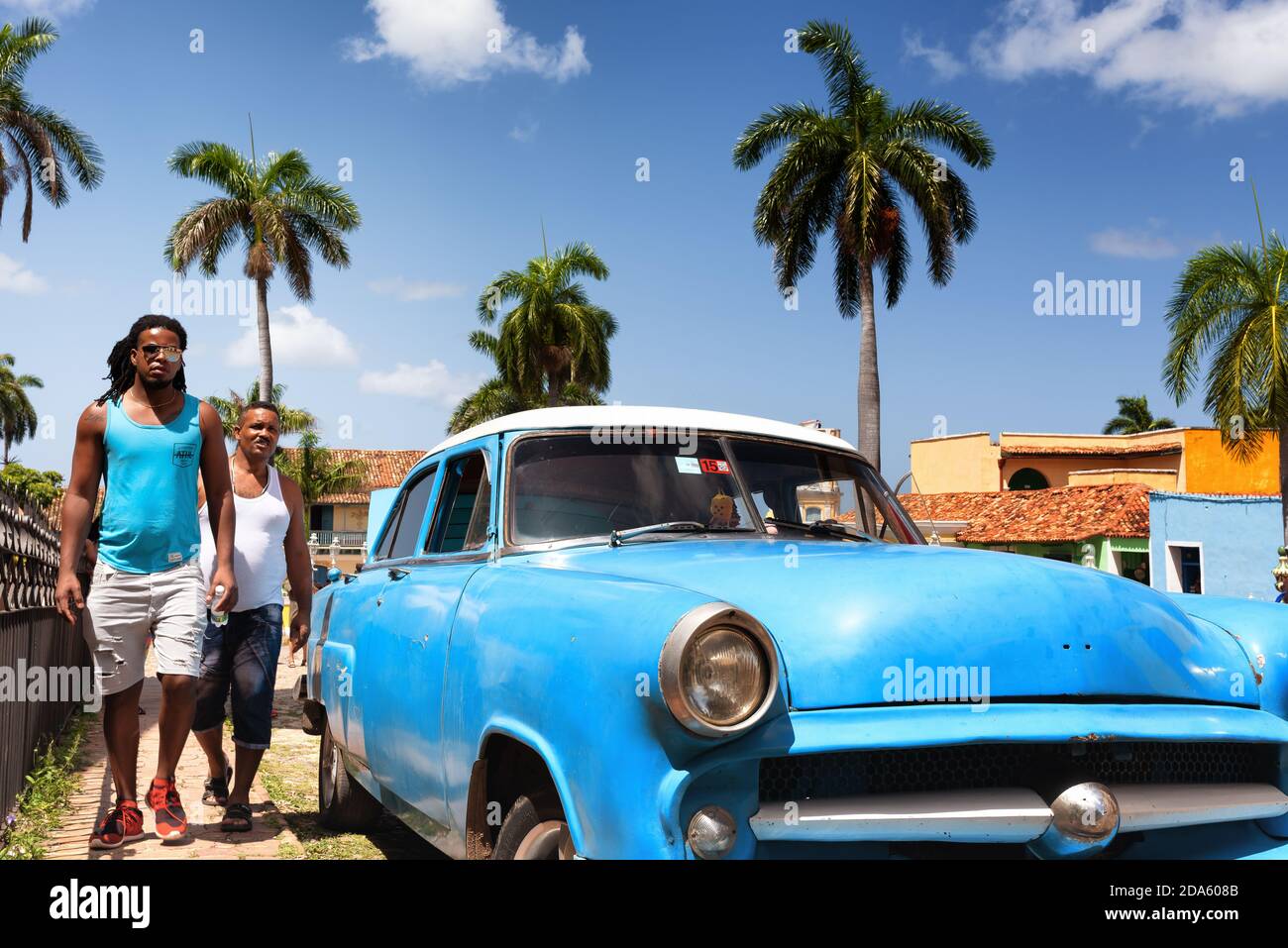 Street scene with a vintage American car and walking cuban people. Trinidad, Cuba. Stock Photo