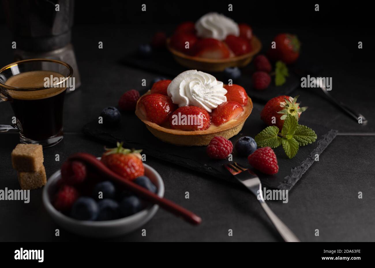 Homemade organic strawberry pie with raspberry and blue berry with a coffee on a dark background. Stock Photo