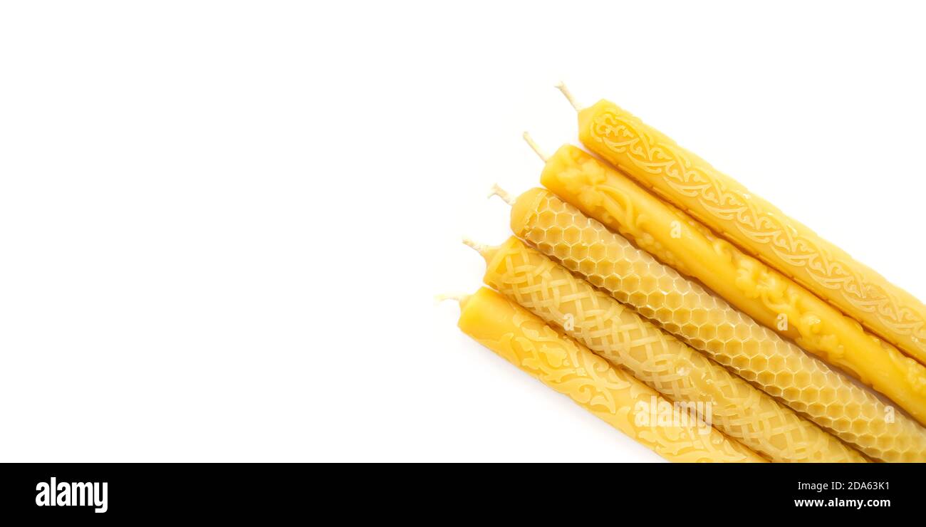 Large yellow candles with different cut out pattern on isolated white banner Stock Photo Alamy
