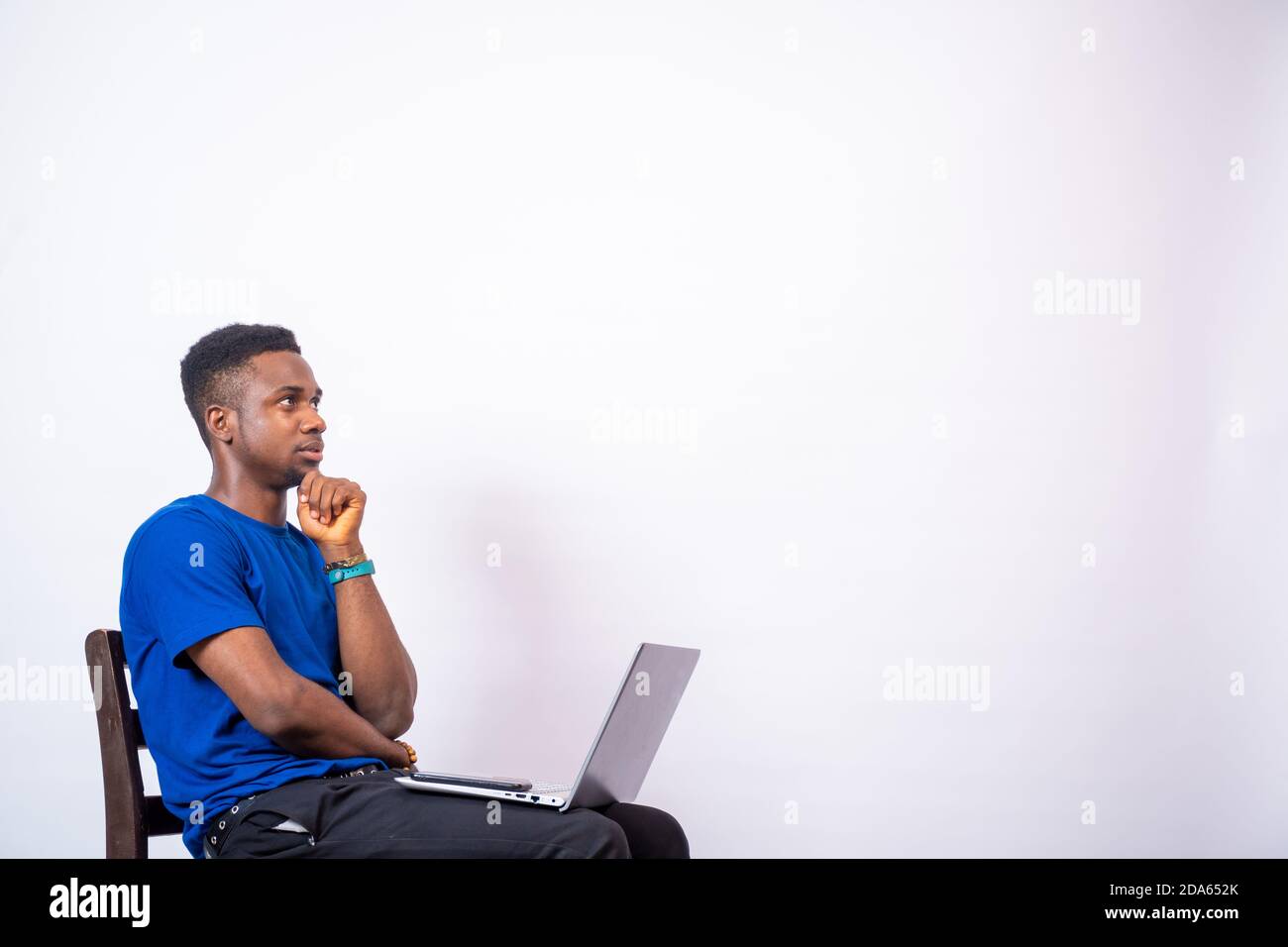 young african man thinking about something while using his laptop Stock Photo