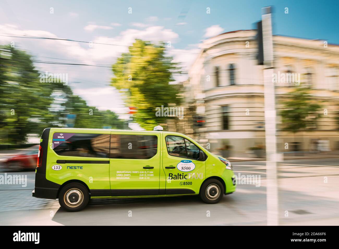 Riga, Latvia. Green Van Car From Baltic Taxi Moving On Street In Riga, Latvia Stock Photo