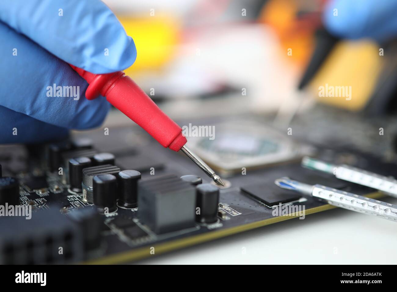 Gloved master holds probe over microcircuit closeup Stock Photo