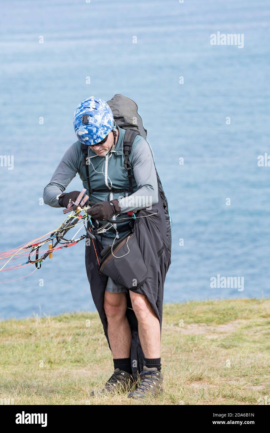 A middle aged male paraglider prepares himself for take off at the popular launch point of Bald Hill, Stanwell Tops, New South Wales, Australia Stock Photo