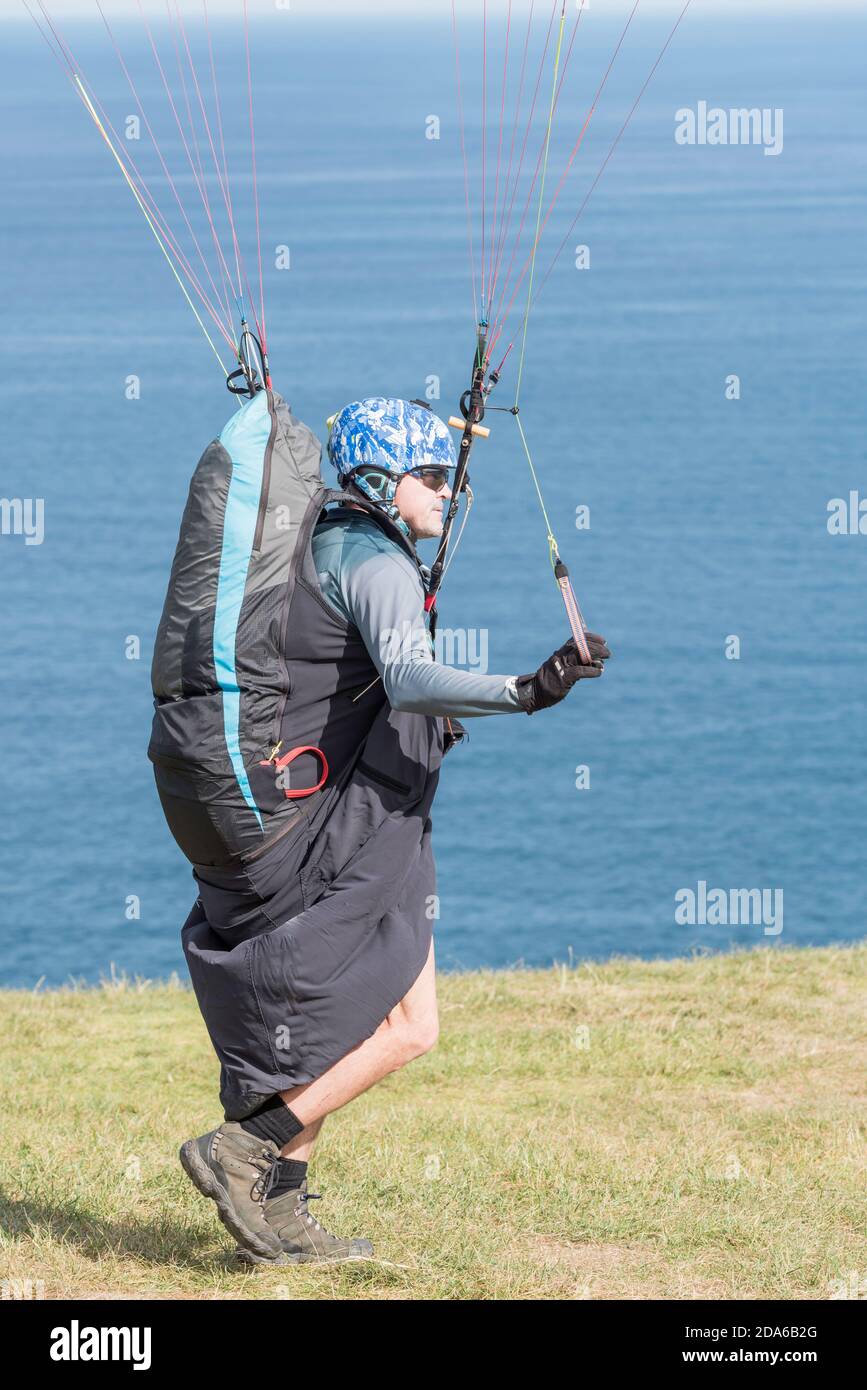A middle aged male paraglider prepares himself for take off at the popular launch point of Bald Hill, Stanwell Tops, New South Wales, Australia Stock Photo