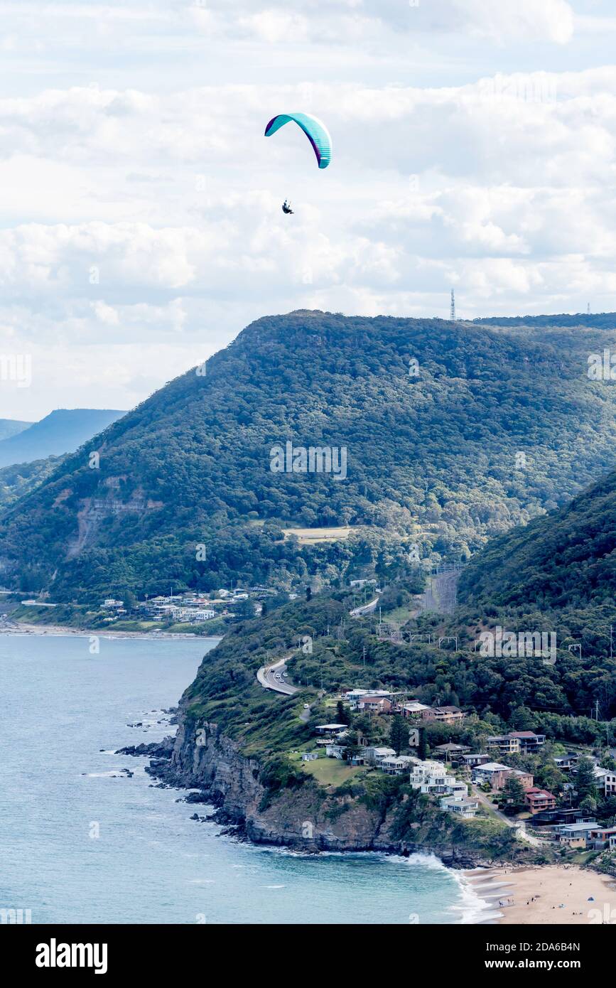 Looking down to Stanwell Park Beach and a paraglider flying, from the popular launch point of Bald Hill, Stanwell Tops, New South Wales, Australia Stock Photo