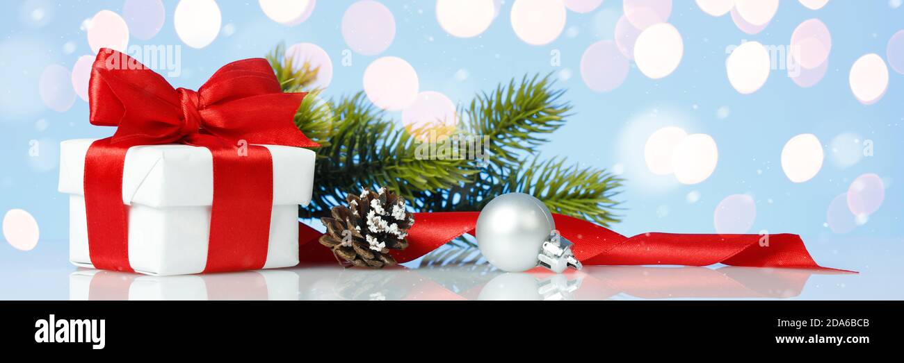 Christmas gift box with red bow and decorations on blue background Stock Photo