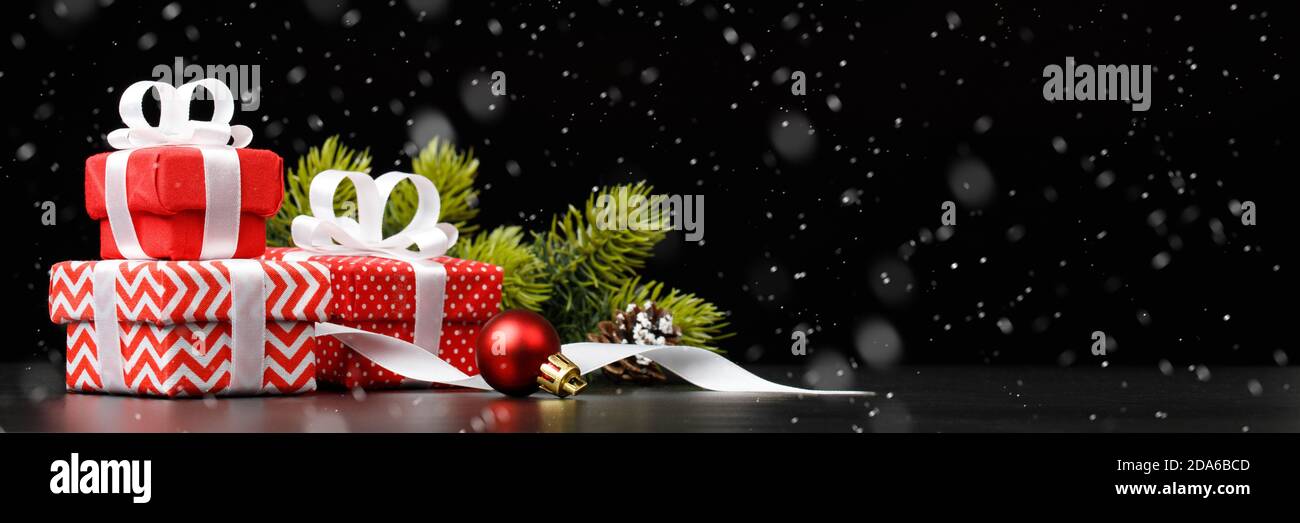 Red gift boxes with christmas decorations on black background Stock Photo