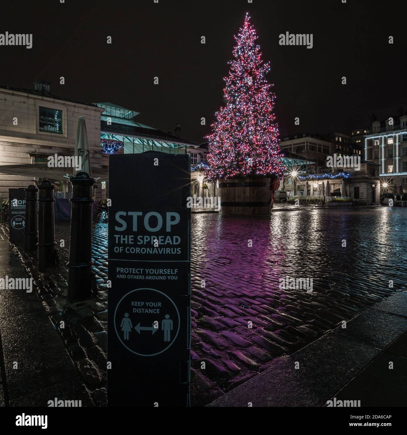 Rain and reflections at nightfall around the christmas tree in Covent