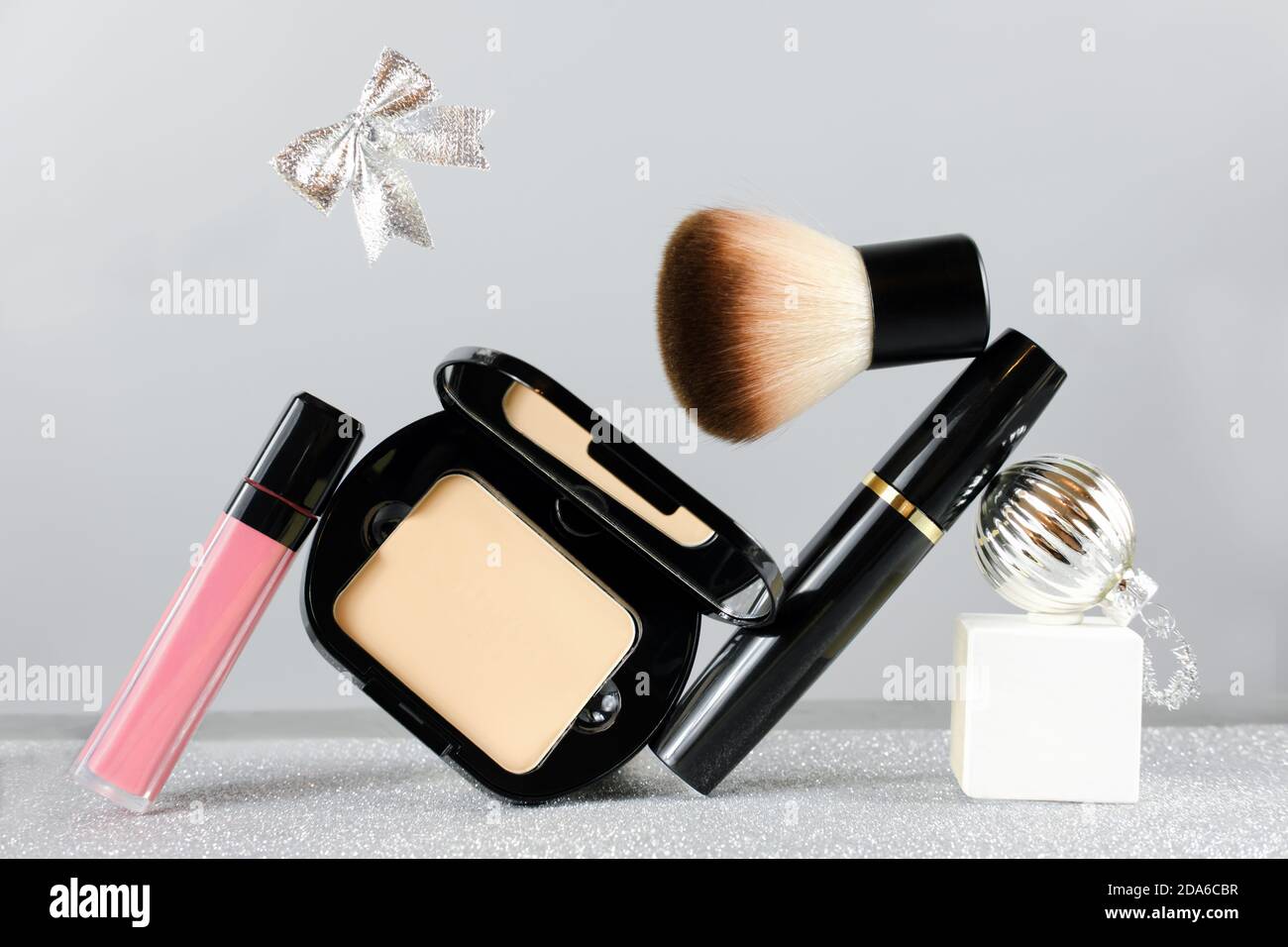 set of professional decorative cosmetics, makeup beauty, fashion and  shopping concept. christmas gift. face powder, lipstick, brush and mascara  with christmas ball and ribbon bow Stock Photo - Alamy