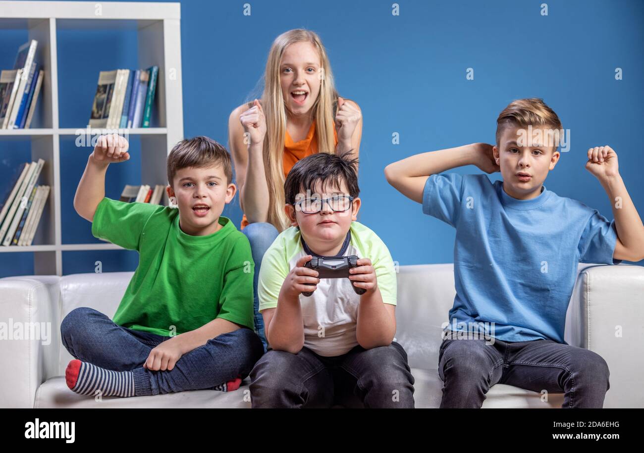 Teenager friends having fun, playing computer games, after all the school homework is done. Stock Photo