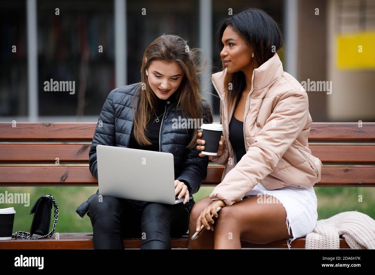 Two girls sitting on park bench hi-res stock photography and images - Alamy