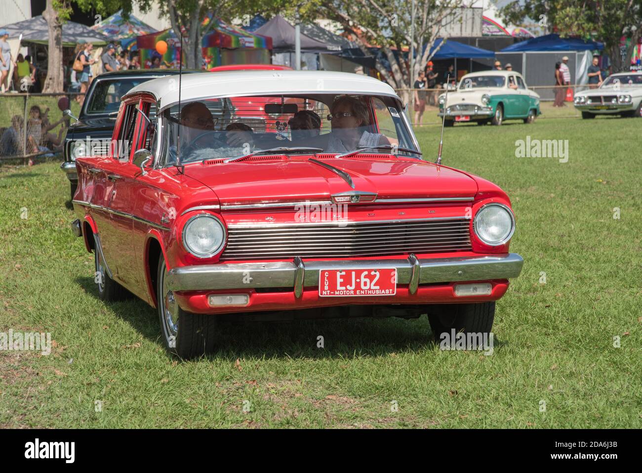 Darwin, NT, AustraliaJuly 27,2018 Red vintage Holden car in parade procession with spectators