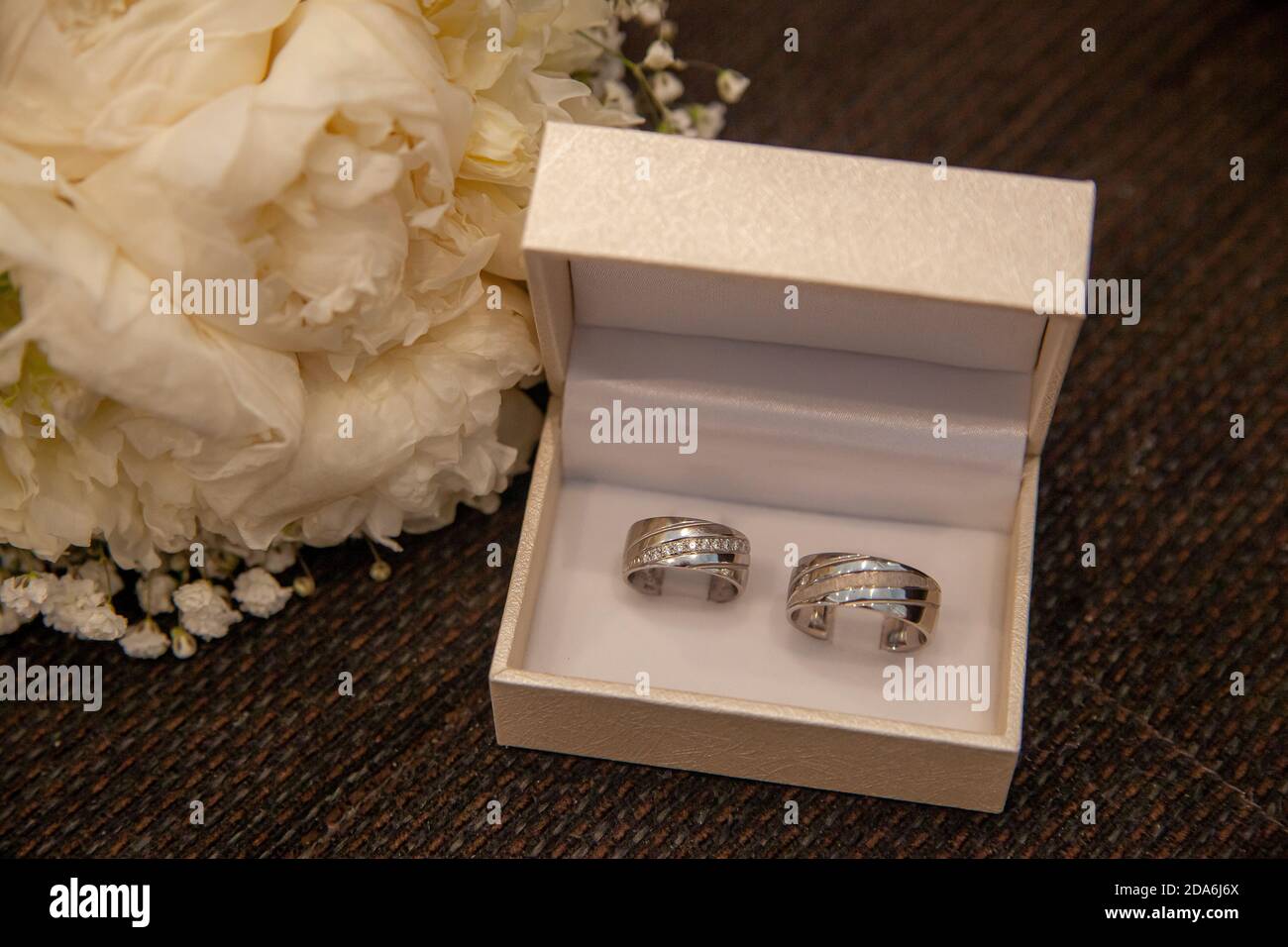 Wedding rings in a box next to a bouquet made of white roses Stock ...