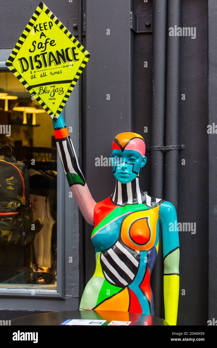 A colourful mannequin on the street is holding a diamond shape board to inform the public to keep a safe distance. Singapore. Stock Photo