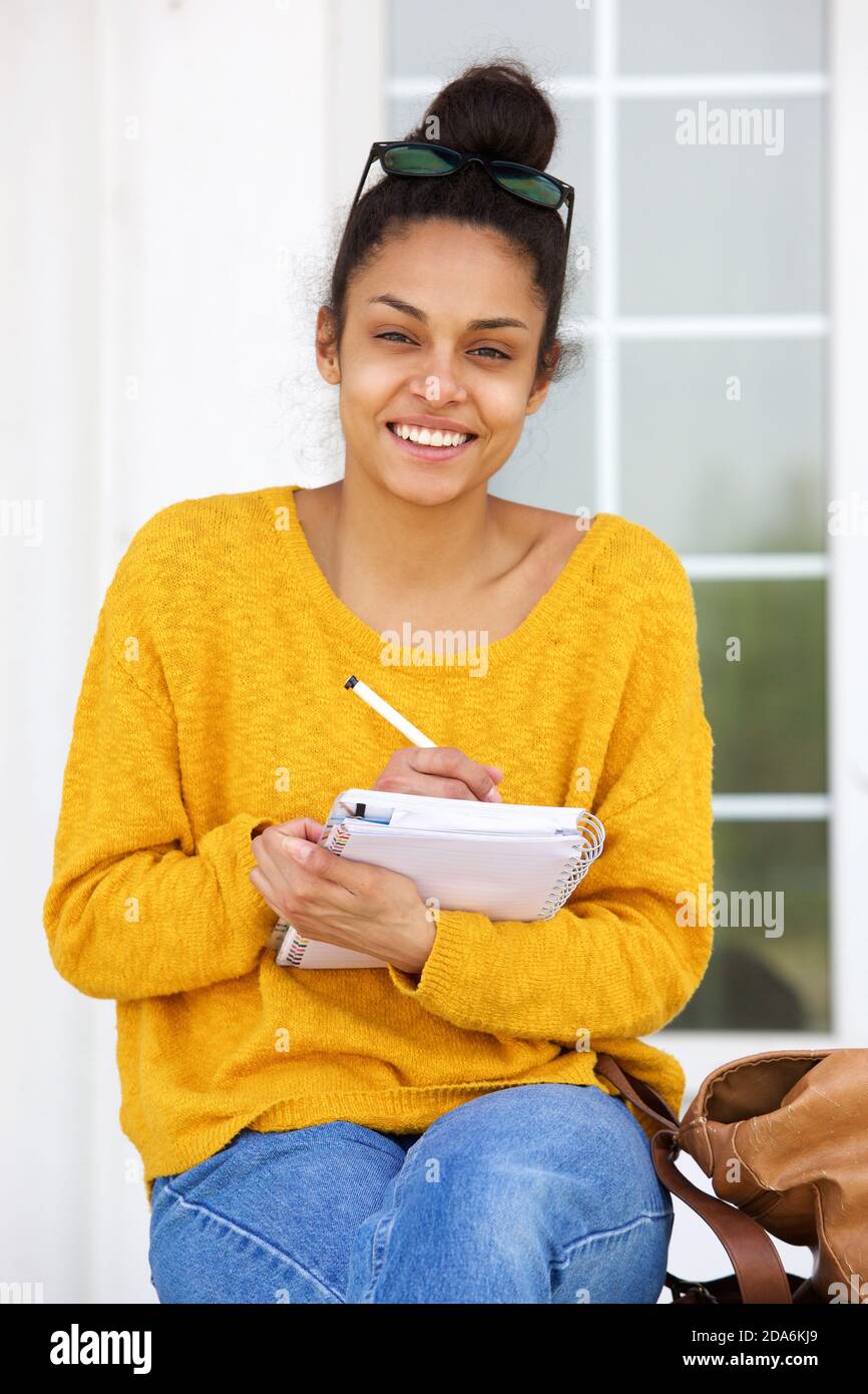 Portrait of beautiful young african american woman sitting outside ...