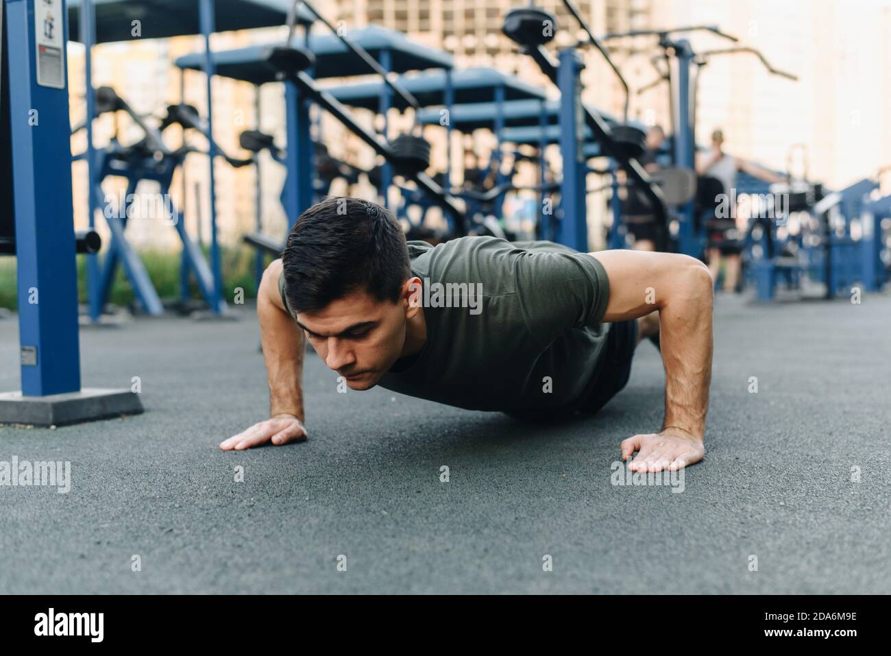 Young man doing push ups outdoor. Young handsome runner warming up and ...