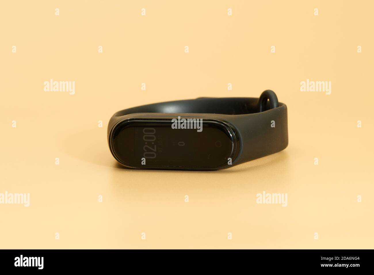Xiaomi mi band 4 laid on peach colored background Stock Photo