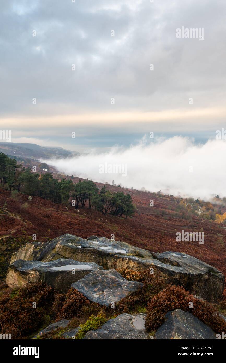 Uk weather: Cloud inversion on an autumnal Ilkley Moor as mist rolls in and out of the Wharfedale valley. Crocodile Rock, Ilkley Moor, West Yorkshire, Stock Photo